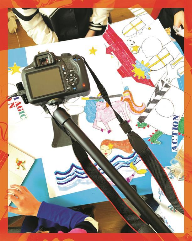 Gemaltes Plakat mit diversen Figuren und einer Digitalkamera